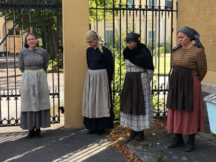 Kvinnor klädda i medeltida kläder i stadsmiljö